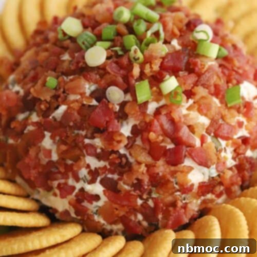 Kickin' Jalapeño Cheese Ball 6 A close-up of a rustic jalapeno bacon cheddar cheese ball adorned with fresh scallions and crispy bacon bits, surrounded by golden Ritz Crackers, indicating a savory and delightful appetizer.