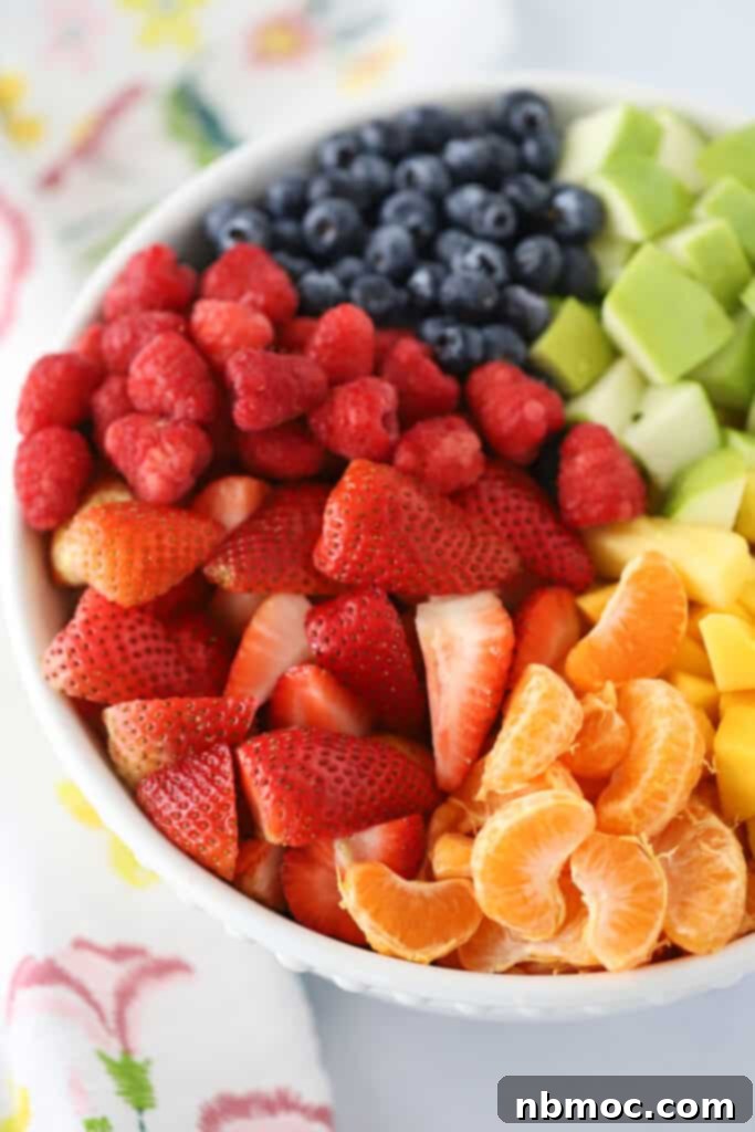Vibrant Fruit Medley 2 Rainbow fruit salad in a large white serving bowl, a colorful selection of fresh fruit.