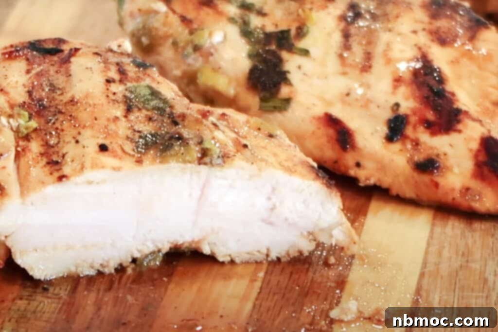 Zesty Cilantro Lime Chicken 7 Succulent cilantro lime marinated grilled chicken, perfectly sliced on a cutting board, ready to be served with creamy avocado drizzle.