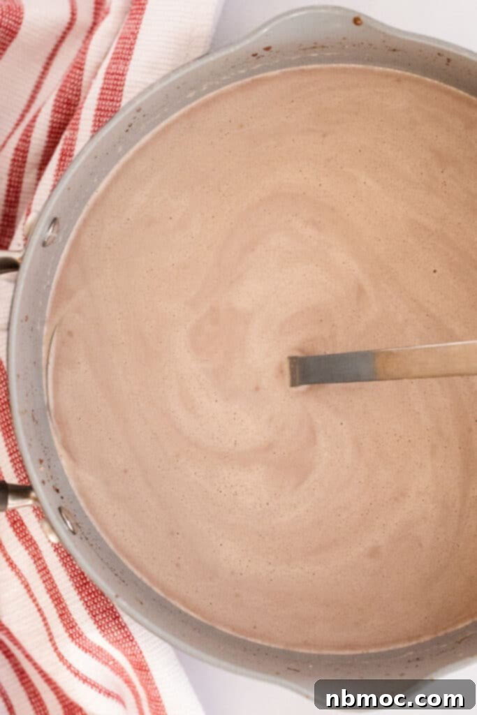 A large pot of hot chocolate with a ladle, showcasing the rich, dark color and creamy texture. Perfect for a crockpot or stovetop recipe.