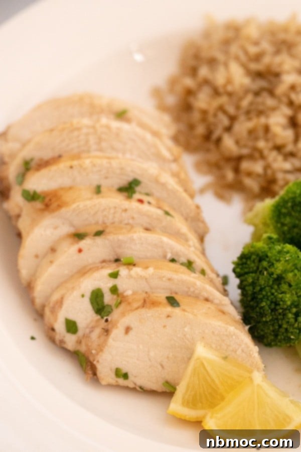juicy baked chicken breast recipe; ginger lemon chicken; best lemon chicken. A plate of sliced lemon ginger chicken, showcasing its juicy interior.