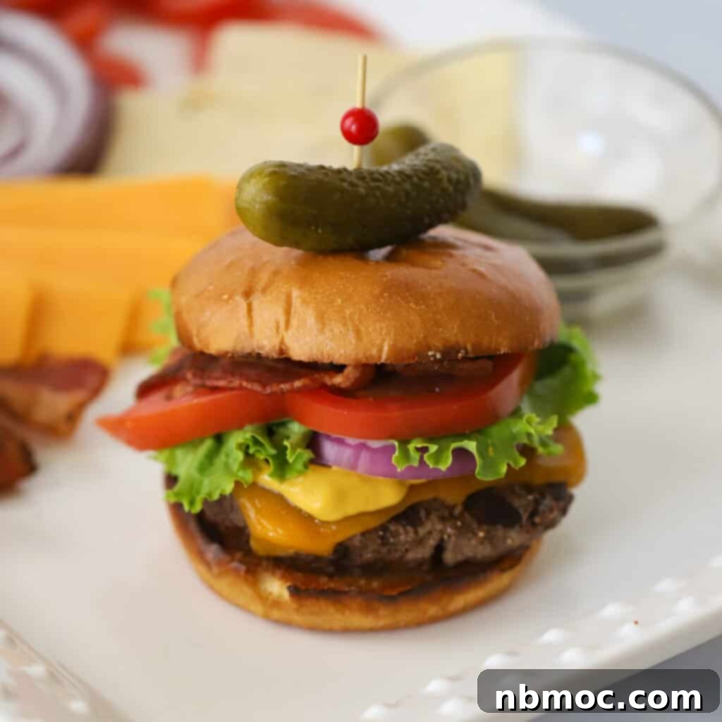 A perfectly cooked homemade hamburger with melted cheese, lettuce, and tomato, ready to be served on a toasted bun. Showcases the best homemade hamburger recipe.