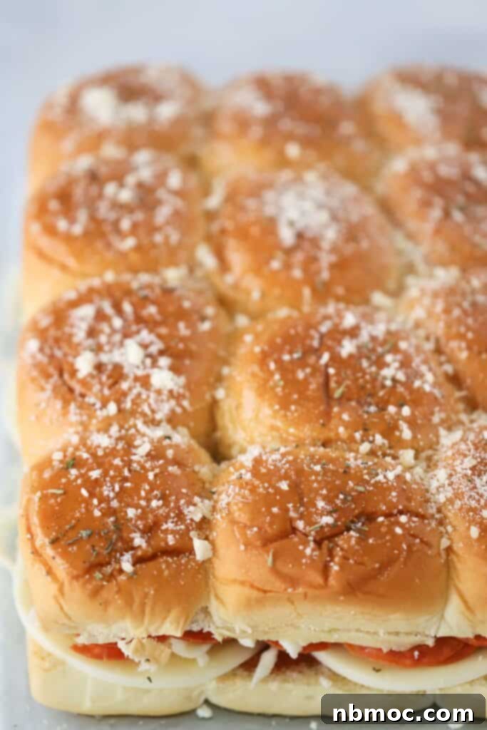 A large tray filled with golden brown Kings Hawaiian Roll Pizza Sliders, ready to be served, showcasing the melted cheese and pepperoni.