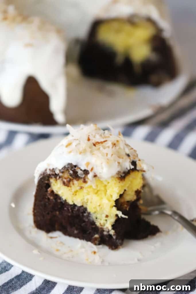 A slice of chocolate coconut bundt cake topped with glaze and toasted coconut flakes.