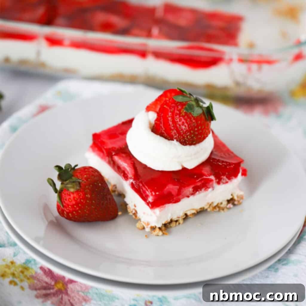 a square piece of strawberry salad recipe with whipped cream and a strawberry, recipe for strawberry pretzel salad..