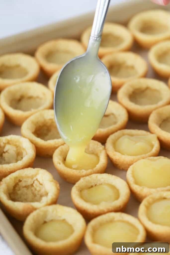 Close-up of freshly baked Lemon Cookie Cups, featuring sugar cookie cups with a glossy lemon curd filling. These are perfect lemon cookies for any occasion.