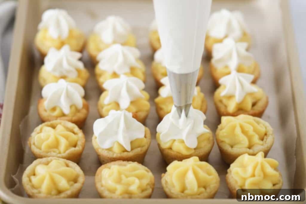 Banana Dream Cookie Cups 3 A piping bag with a star tip is used to pipe whipped cream on top of each banana cream cookie cup, adding a beautiful finish.