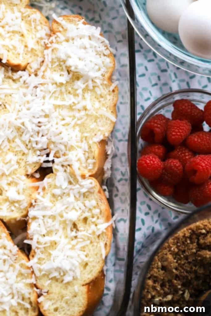 A pan of sliced bread topped with coconut and a side of berries for making a french toast casserole.