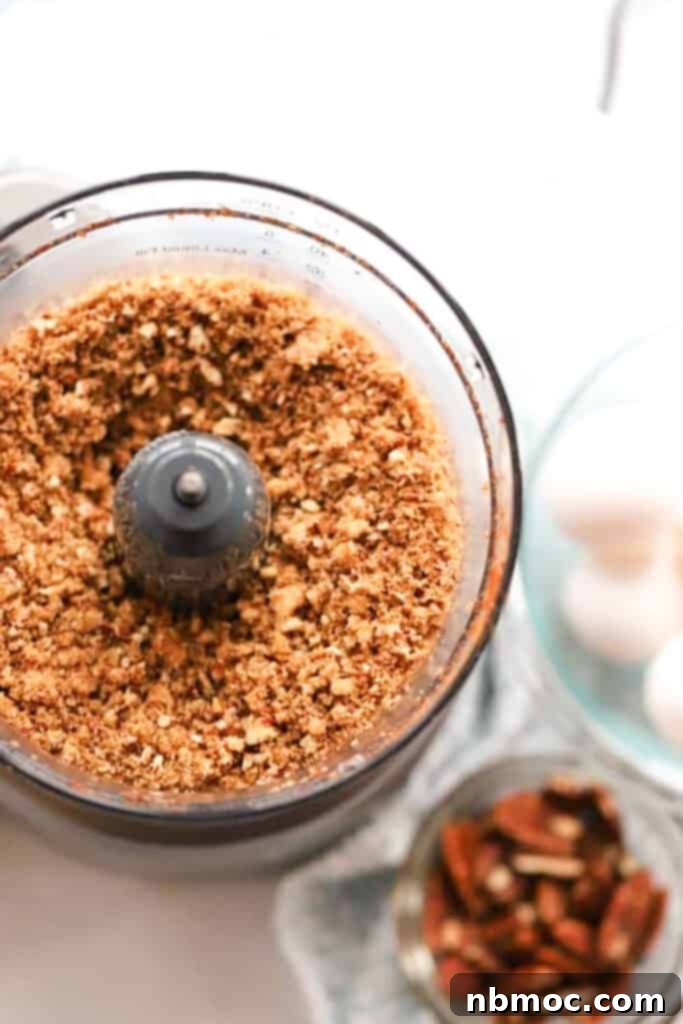 A food processor with pecans for making crumble.
