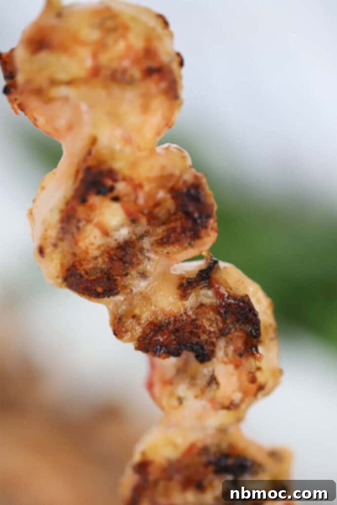 Grilled Bang Bang Shrimp Kabobs 3 A close-up of a grilled Bang Bang shrimp skewer, generously coated in the signature sweet and spicy sauce.