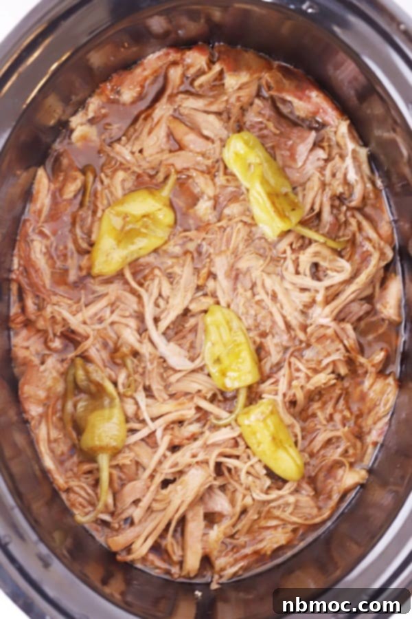 mississippi pork roast shredded in a crockpot and topped with pepperoncini.