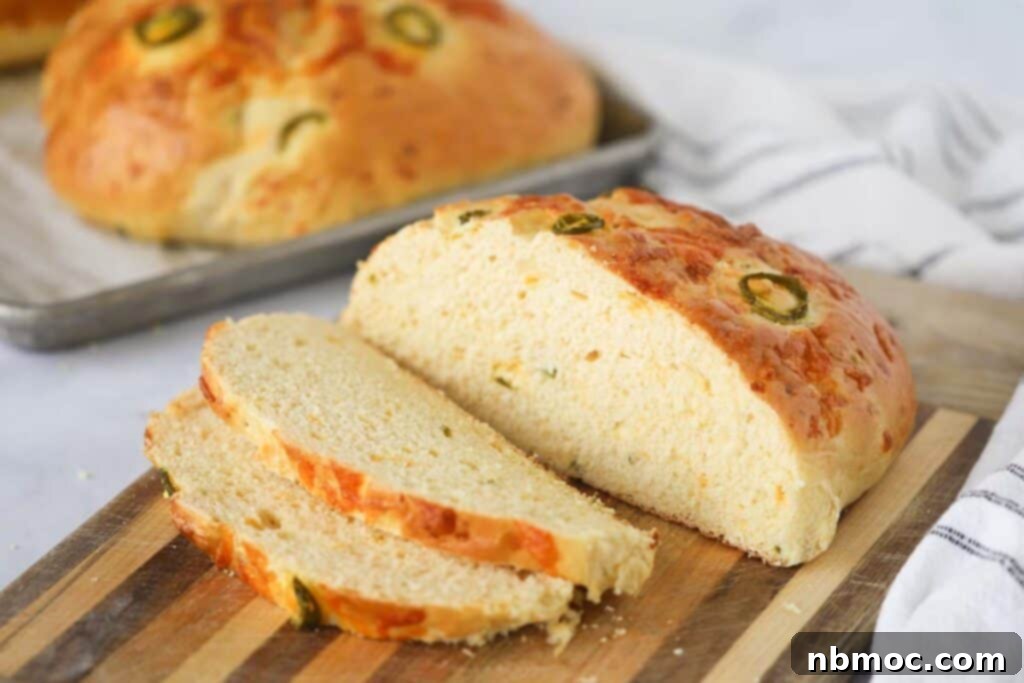 Sliced cheddar jalapeno bread on a cutting board, how to make homemade bread, cheesy bread recipe.