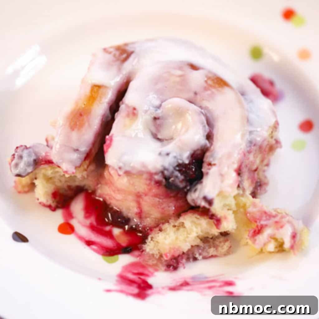 A delightful triple berry sweet roll topped with zesty lemon icing, offering a fruity cinnamon roll variation.
