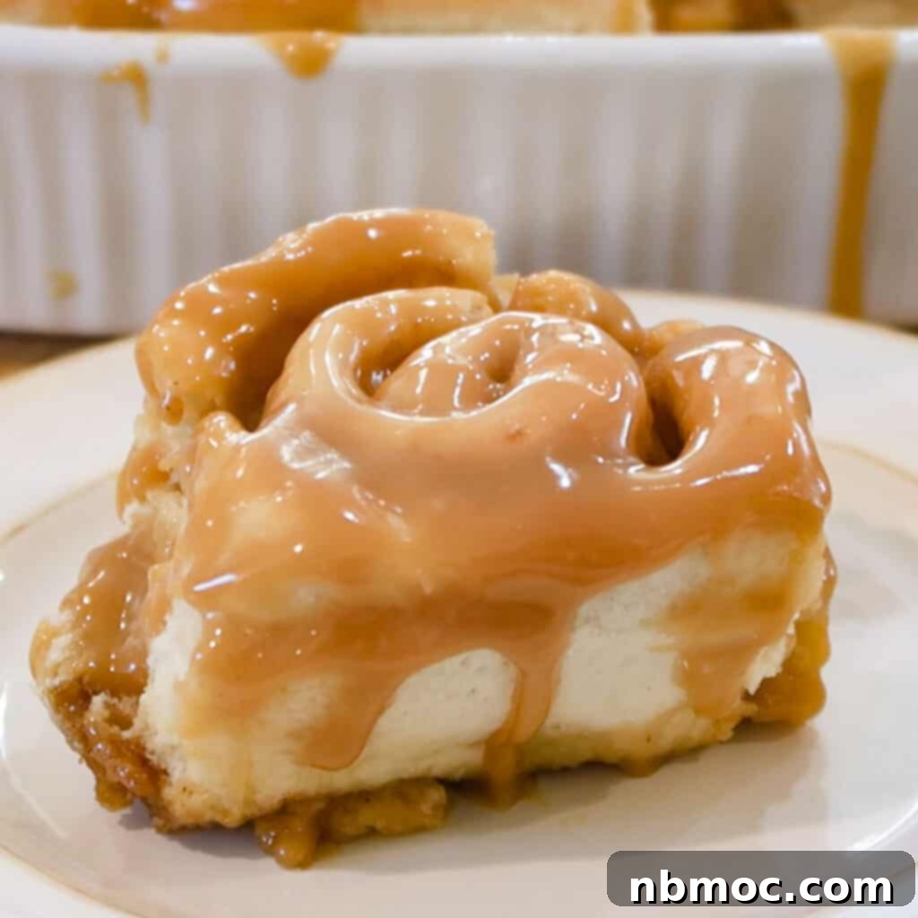 Delicious Caramel Cinnamon Rolls, glistening with a generous caramel topping, served on a pristine white plate.