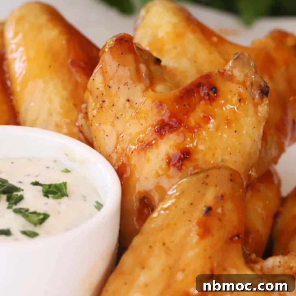 Ultimate Buffalo Chicken Dishes 3 Succulent Buffalo chicken wings served alongside a small bowl of creamy ranch dressing, ready for dipping.