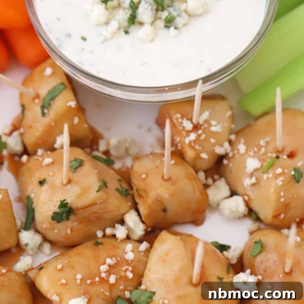 Ultimate Buffalo Chicken Dishes 7 Appetizing buffalo chicken bites, served with toothpicks and garnished with blue cheese crumbles, perfect for a party.