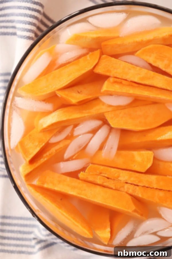 Crispy Sweet Potato Fries with Zesty Dipping Sauce 2 Sweet potato fries soaking in ice water to enhance crispiness before baking.