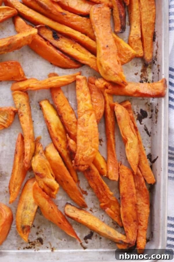 Crispy Sweet Potato Fries with Zesty Dipping Sauce 3 Crispy baked sweet potato fries seasoned and ready for the oven on a baking sheet.