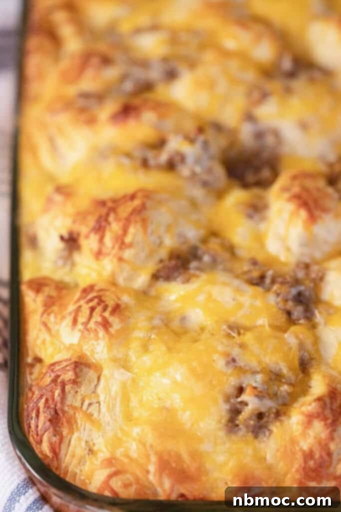 Effortless Sausage Egg Biscuit Brunch Bake 3 A large baking dish filled with a golden-brown biscuit egg and sausage casserole, featuring large pieces of refrigerated biscuits.