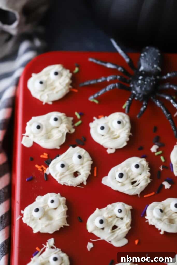 spooky halloween pretzels decorated to look like little mummies with candy eyes.