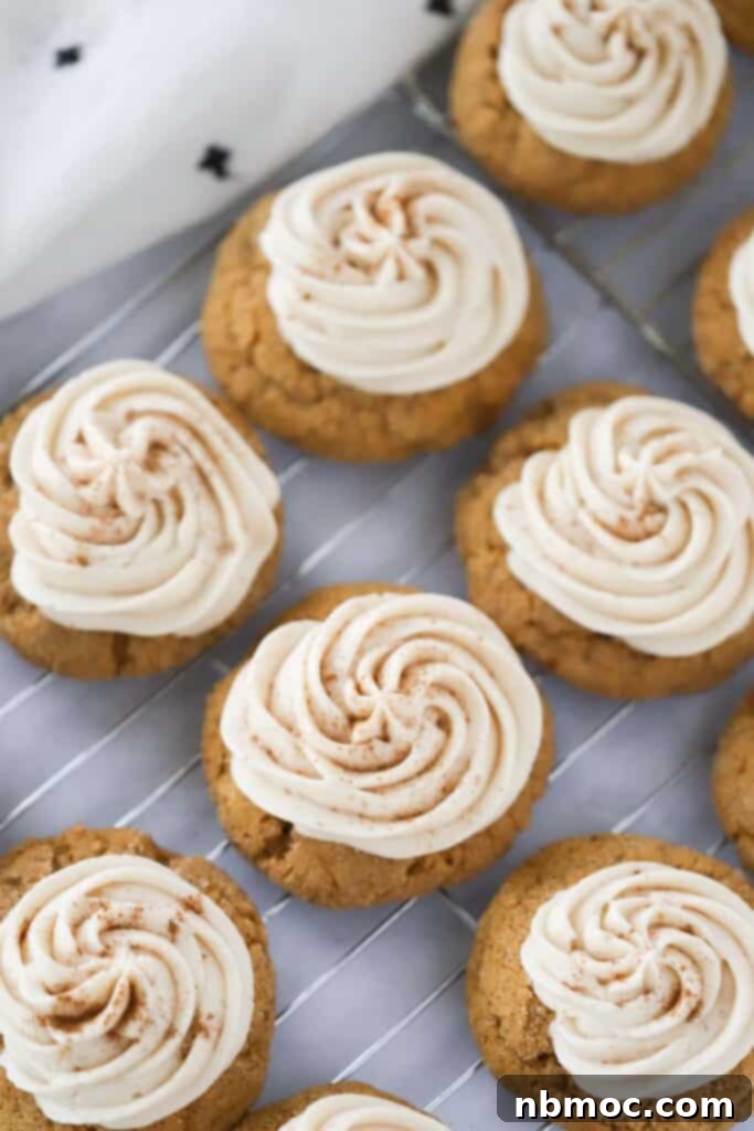 Dreamy Pumpkin Cream Cheese Cookies 3 Creamy cream cheese frosting elegantly piped onto soft pumpkin cookies resting on a wire rack.