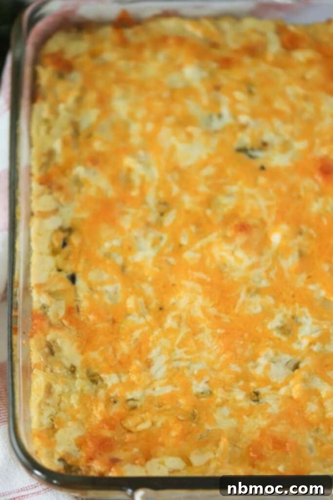 best cheesy potato recipes, spicy cheesy potatoes with real potatoes, cheesy potato casserole, best cheesy potatoes with green chilis. A freshly baked spicy green chile cheesy potato casserole, golden and bubbly.
