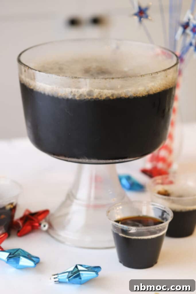 Crafting Your Own Root Beer 2 A large punch bowl filled with homemade root beer, gently fizzing with dry ice, creating a spooky, misty effect perfect for a Halloween party. The scene is festive and inviting, highlighting the visual appeal of the drink.