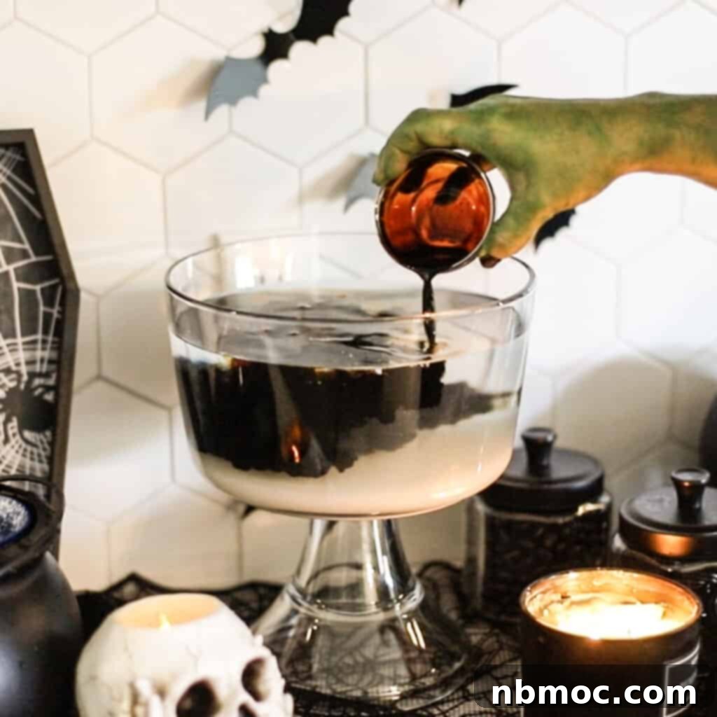 Crafting Your Own Root Beer 4 A whimsical, spooky green hand carefully pouring root beer extract into a large punch bowl, surrounded by playful Halloween decorations. The setup suggests a fun, festive atmosphere for making the homemade root beer.