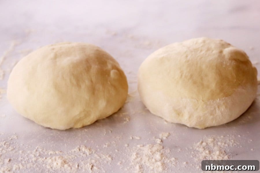 Two balls of Bread dough on a light countertop.