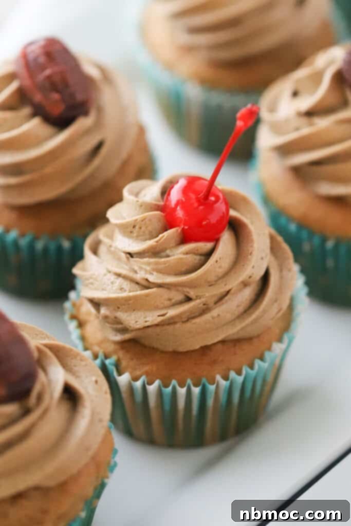 Frothy Root Beer Cupcakes 2 Root beer float cupcakes topped with root beer buttercream frosting and maraschino cherries.