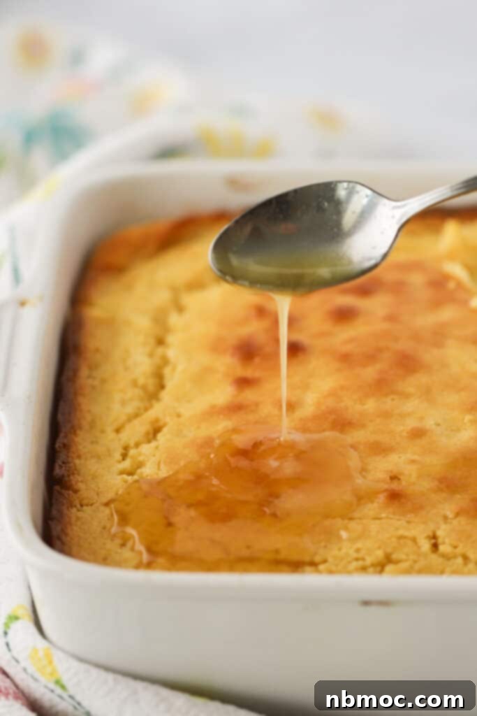 Creamed corn casserole in a baking dish with a luscious drizzle of honey butter, ready to be served.