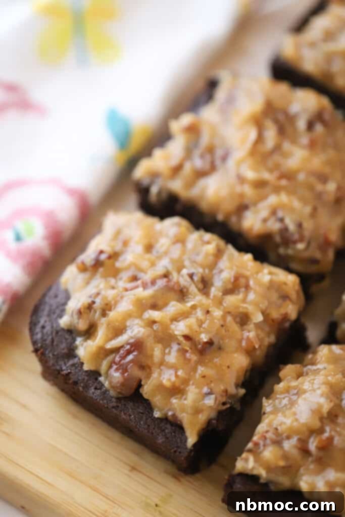 German Chocolate Dream Brownies 2 A cutting board with squares of German Chocolate Brownies with a coconut and pecan topping.