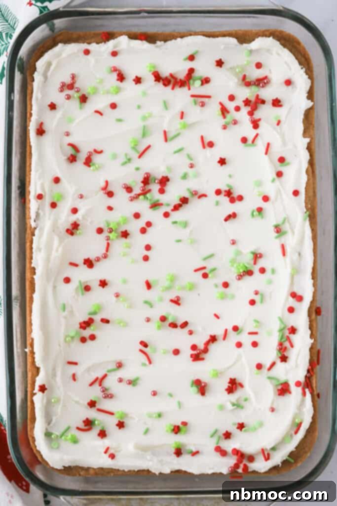 A baking dish filled with festive Christmas Sugar Cookie Bars, showcasing the creamy buttercream frosting and colorful holiday sprinkles.