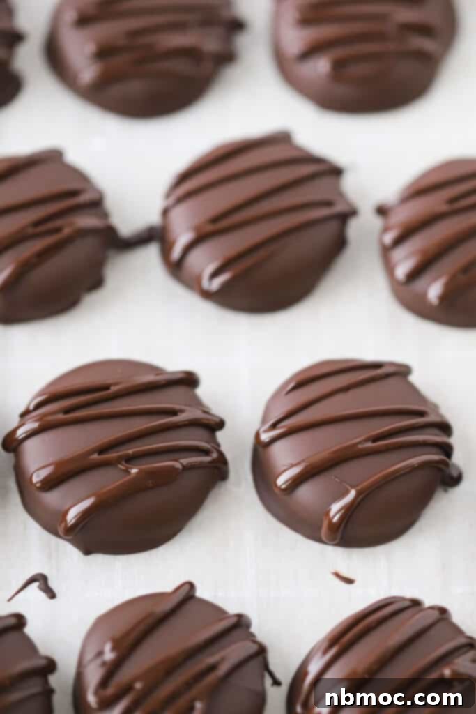 A tray of freshly made Homemade Peppermint Patties drizzled with dark chocolate, ready for holiday gifting.