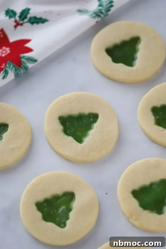 Jewel Window Cookies 2 Beautiful Stained Glass Window Cookies cut with christmas tree cookie cutters, featuring vibrant melted hard candy centers, perfect for easy festive baking.