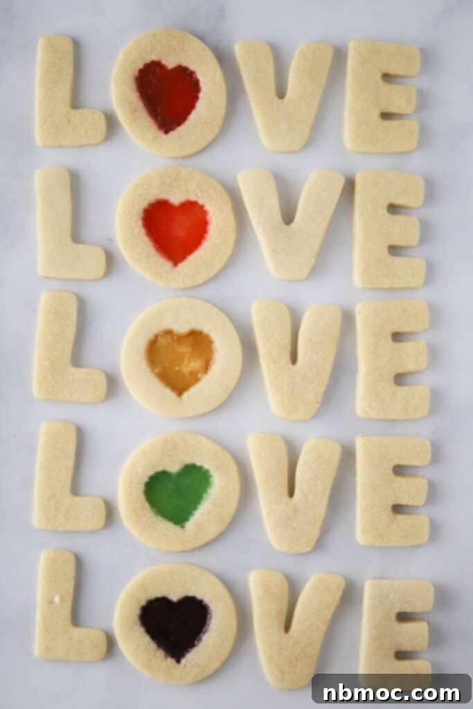 Jewel Window Cookies 3 An array of freshly baked Stained Glass Cookies, each with a soft almond cookie base and colorful melted hard candy centers, showcasing various cookie cutter shapes.