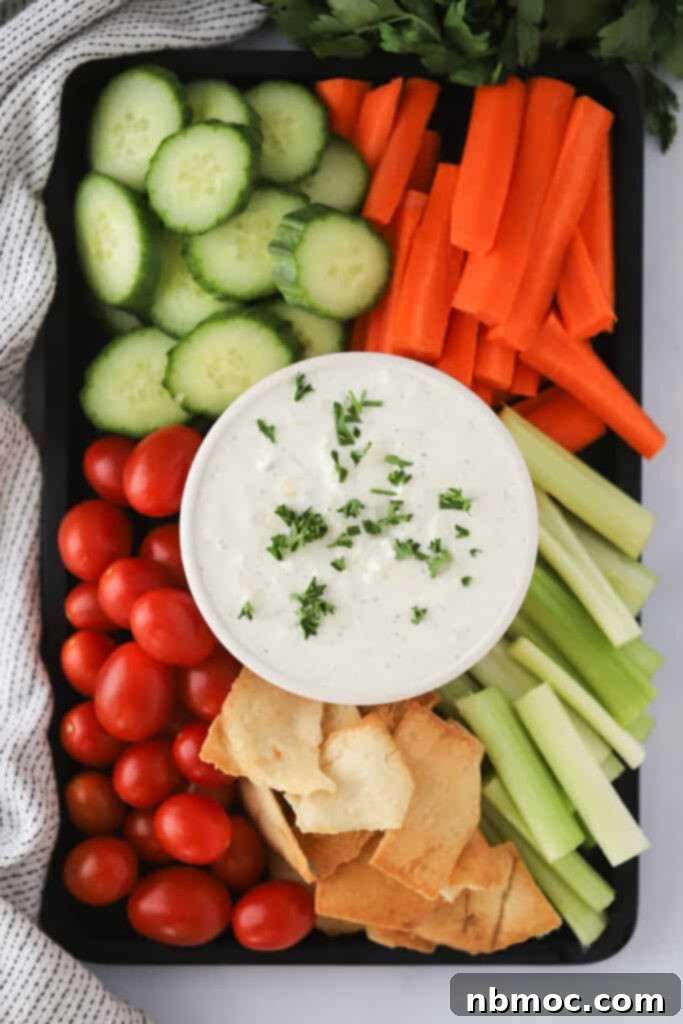The Ultimate Refreshing Greek Yogurt Dip 2 A vibrant veggie tray showcasing a ramekin of homemade Tzatziki Sauce, surrounded by an assortment of colorful fresh vegetables, ready for dipping.