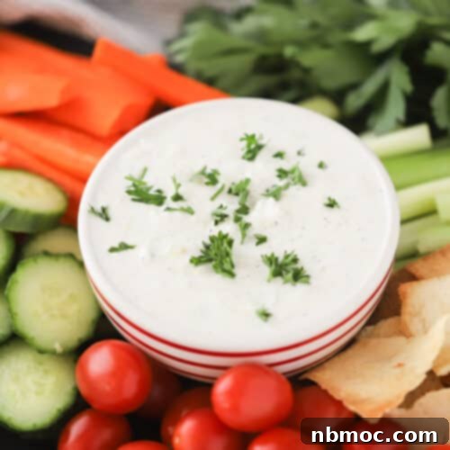 The Ultimate Refreshing Greek Yogurt Dip 4 A close-up shot of creamy Homemade Tzatziki Sauce, garnished with fresh herbs, ready to be served.