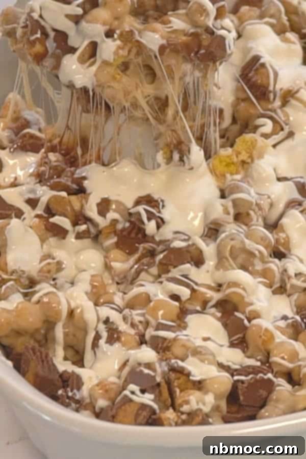 A baking dish full of gooey cereal bars, topped with melted chocolate and peanut butter cups.