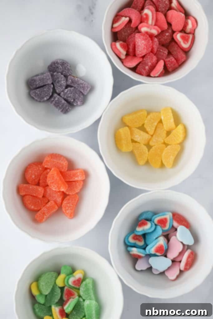 Individual bowls full of different colored gummy candies for making candy kabobs DIY.