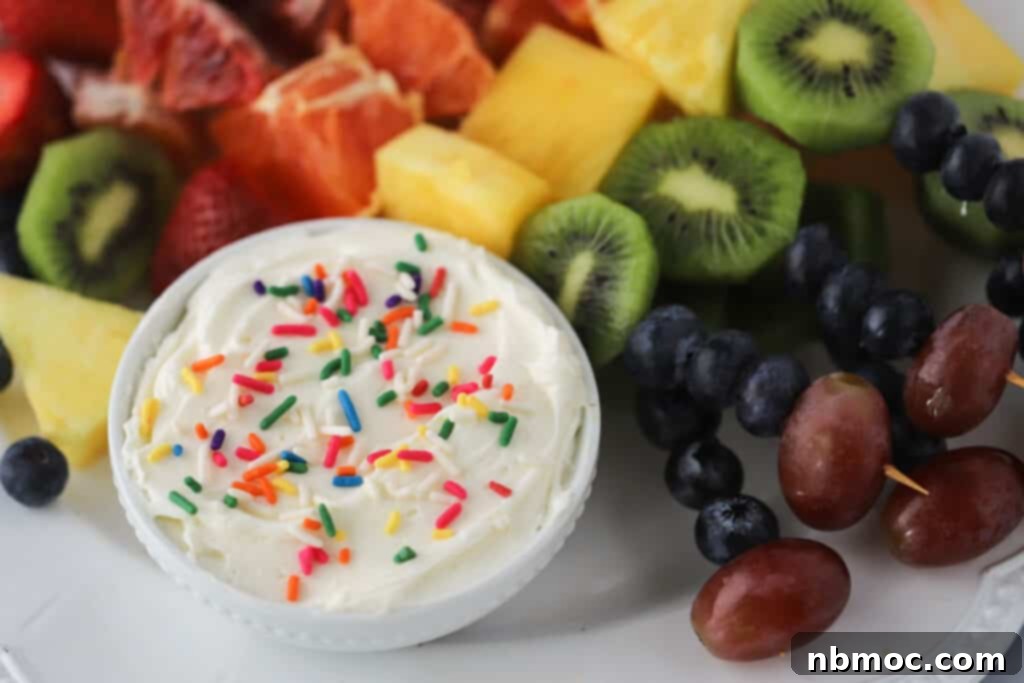 Fruit rainbow skewers made in a rainbow pattern with a side of cheesecake fruit dip. Easter fruit kabobs.