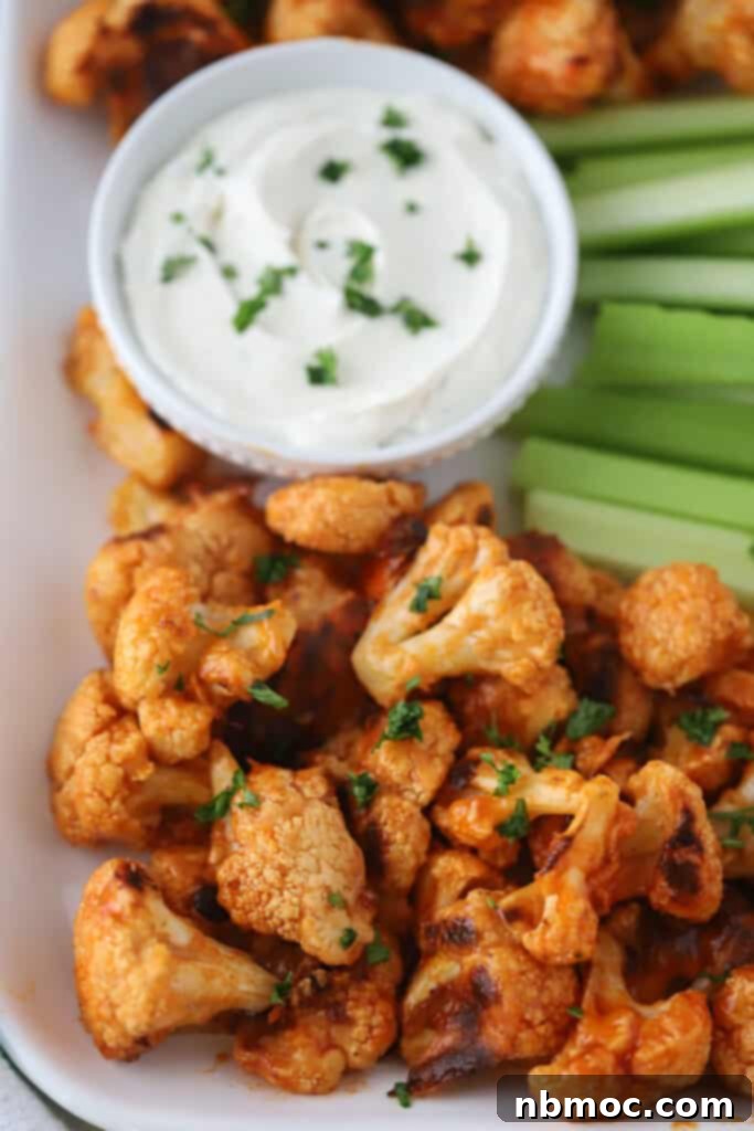 Delicious buffalo cauliflower recipe served with a side of ranch dip and fresh celery sticks.