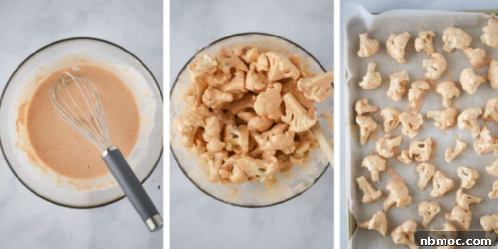 Adding the homemade buffalo sauce batter to cauliflower florets on a baking sheet before roasting.