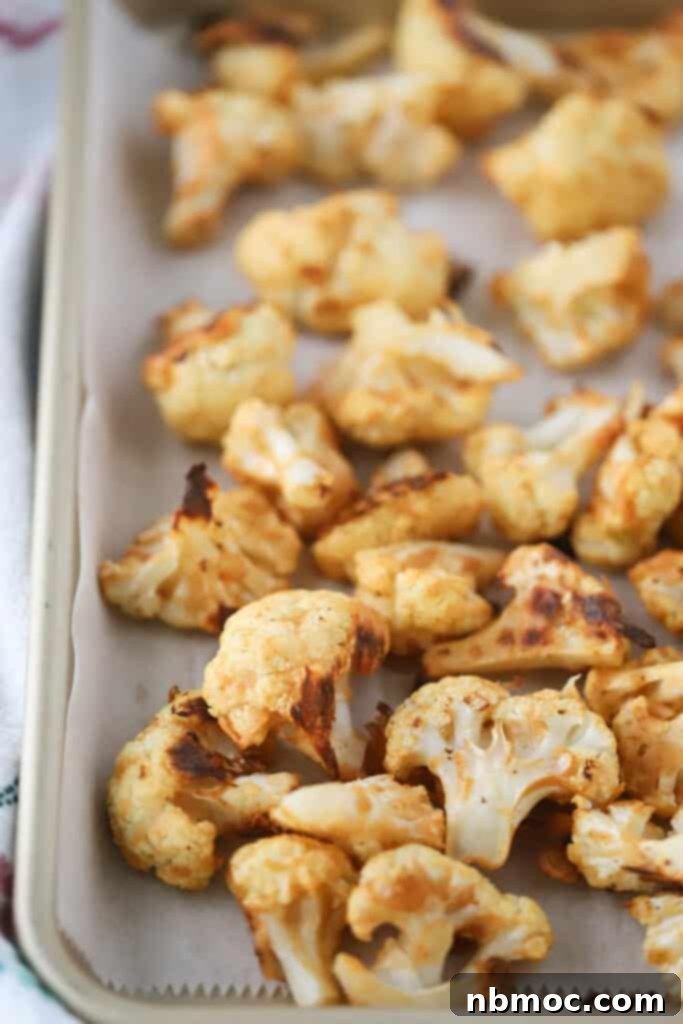 A sheet tray full of freshly baked buffalo cauliflower, ready to be sauced and served.