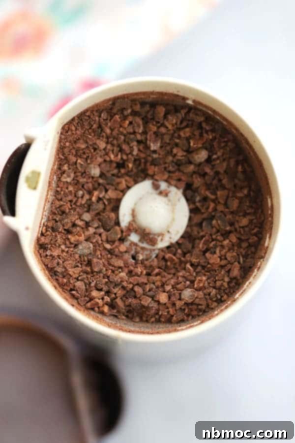 Power-Packed Triple Chocolate Oat Bites 3 Cacao Nibs in coffee Grinder, ready to add to these chocolate energy balls.