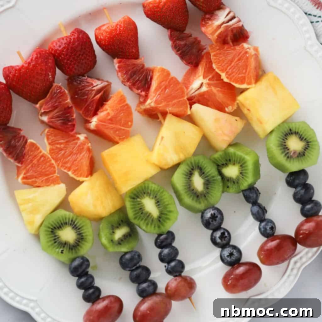 Colorful rainbow fruit kabobs on skewers, a healthy and festive snack for St. Patrick's Day.