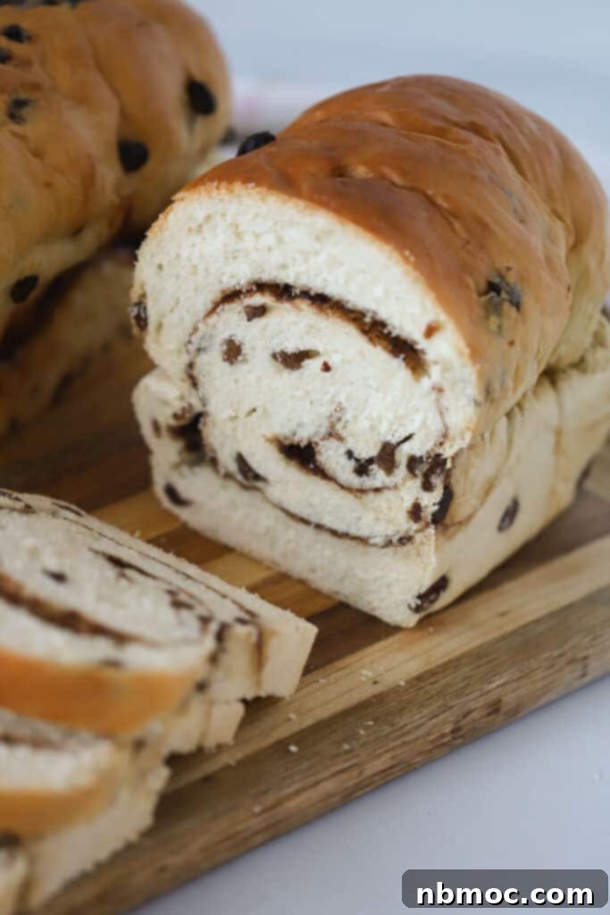 Spiced Raisin Swirl Bread 3 Sliced cinnamon bread recipe with raisins and cinnamon sugar swirl, revealing its irresistible interior.