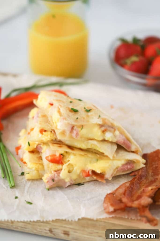 A stack of Breakfast quesadillas filled with scrambled eggs, red pepper, bacon, and ham.