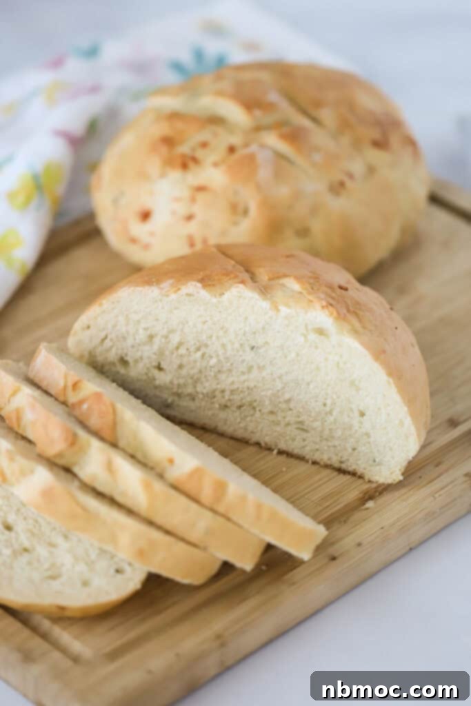 Aromatic Rosemary Bake 2 A cutting board with Rosemary Parmesan Bread being sliced.