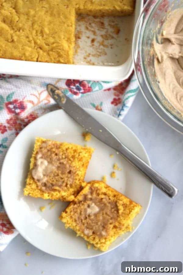 A slice of golden cornbread on a plate, topped with a generous dollop of Texas Roadhouse-style cinnamon whipped honey butter.